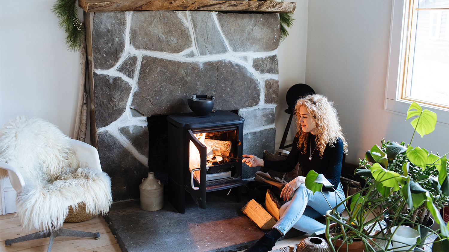 woman adding wood to the fire at home